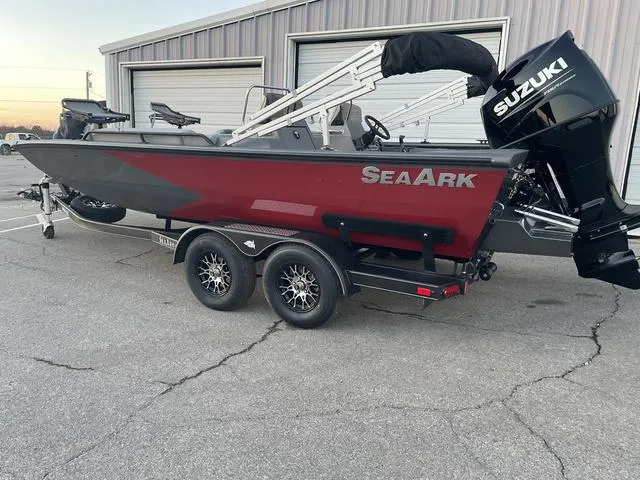 Slide: The Image of 2024 SeaArk Easy 200 boat with Suzuki engine on trailer, parked outside a building. - 2