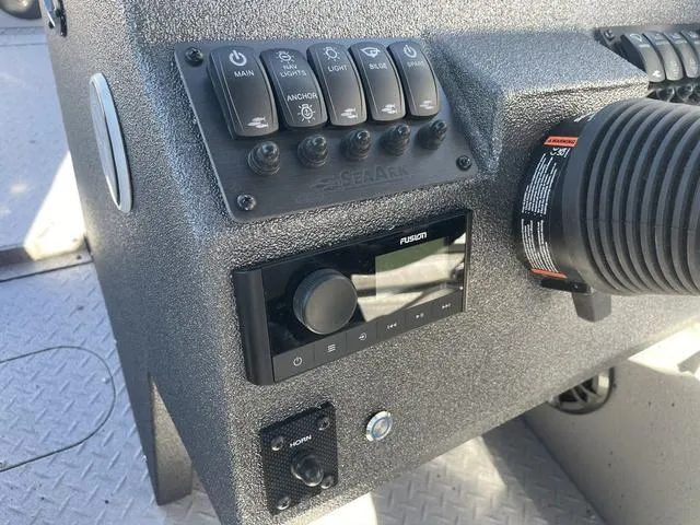 Slide: The Image of Control panel of 2025 SeaArk Pro Cat 240 boat with switches and Fusion audio system. - 12