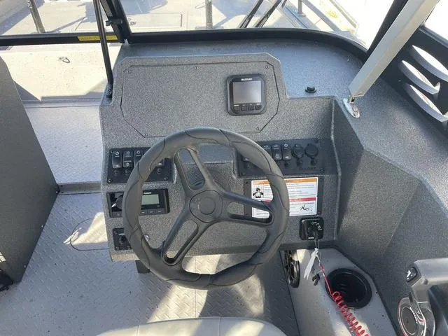 Slide: The Image of 2025 SeaArk Pro Cat 240 boat dashboard with steering wheel and controls. - 14