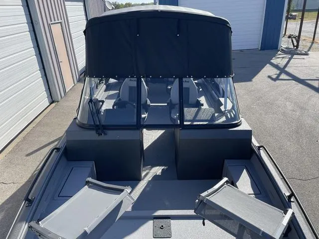 Slide: The Image of 2025 SeaArk Pro Cat 240 boat with canopy, docked near storage facility. - 5