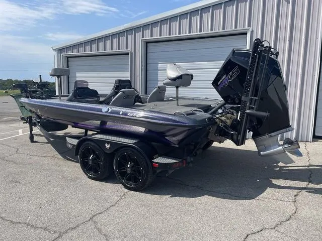 Slide: The Image of 2022 Phoenix 919 Pro XP boat parked outside a metal building. - 2