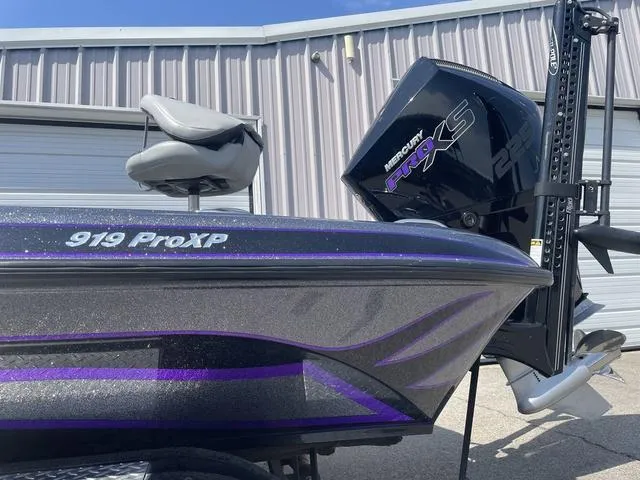 Slide: The Image of 2022 Phoenix 919 Pro XP boat with Mercury engine, parked near a garage. - 3