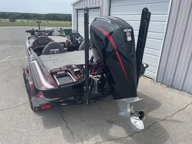 Slide: The Image of 2020 Bass Cat Cougar FTD boat with powerful outboard motor, parked near a garage. - 5