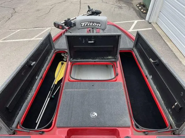 Slide: The Image of 2007 Triton 21 X2 boat interior with storage compartments and paddles. - 12