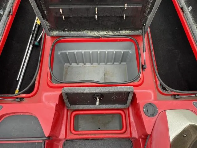 Slide: The Image of 2007 Triton 21 X2 boat storage compartments, open and empty, with red and gray interior. - 14
