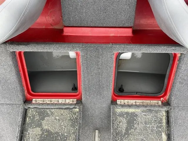 Slide: The Image of 2007 Triton 21 X2 boat storage compartments with red trim and gray interior. - 22