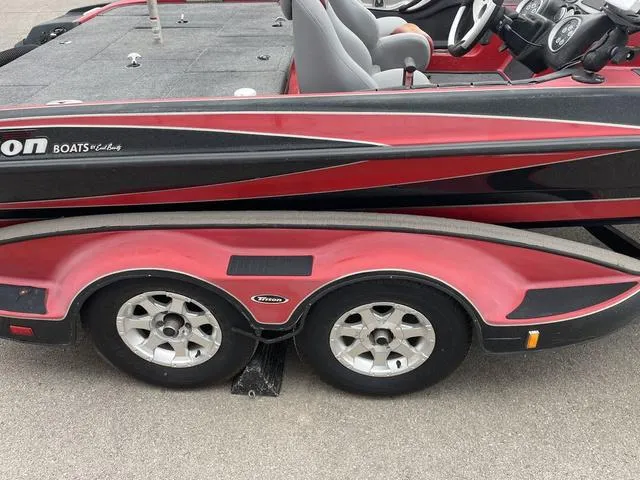 Slide: The Image of 2007 Triton 21 X2 boat with dual-axle trailer, red and black design. - 8
