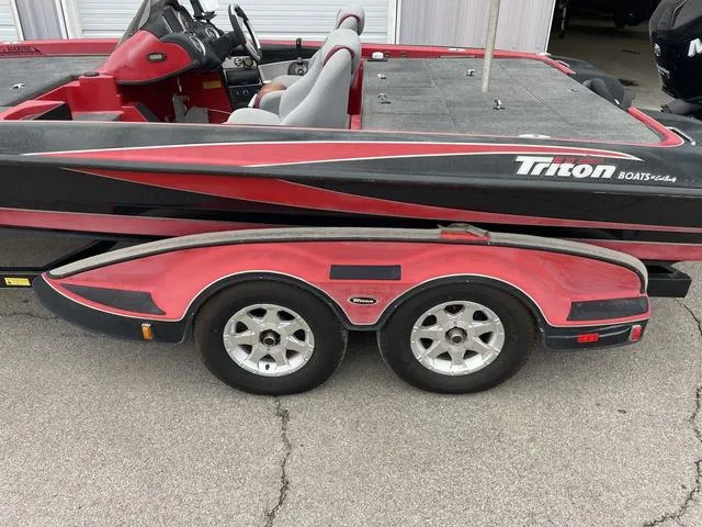 Slide: The Image of 2007 Triton 21 X2 boat with red and black design on a dual-axle trailer. - 9