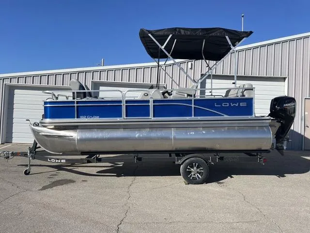 Slide: The Image of 2023 Lowe Ultra 182 Fish & Cruise pontoon boat with canopy, parked on trailer. - 1