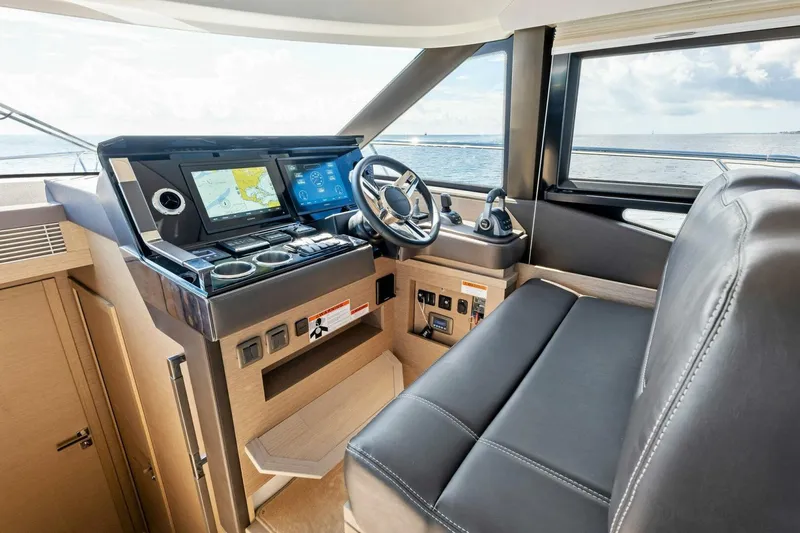 Slide: The Image of Prestige 460 Flybridge 2023 yacht helm with modern navigation system and leather seating. - 16