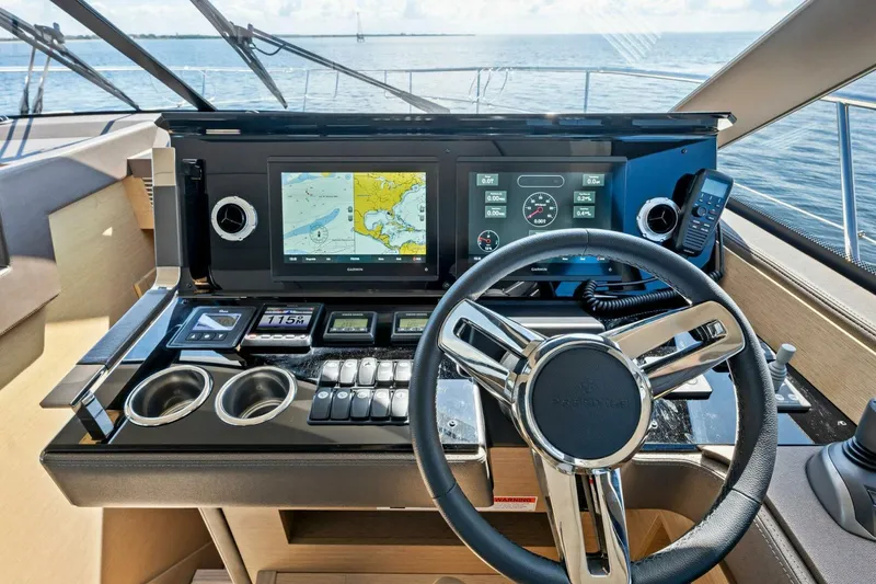 Slide: The Image of Prestige 460 Flybridge 2023 helm with navigation screens and controls, overlooking the ocean. - 18
