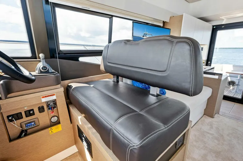 Slide: The Image of 2023 Prestige 460 Flybridge interior with leather seating and control panel. - 19