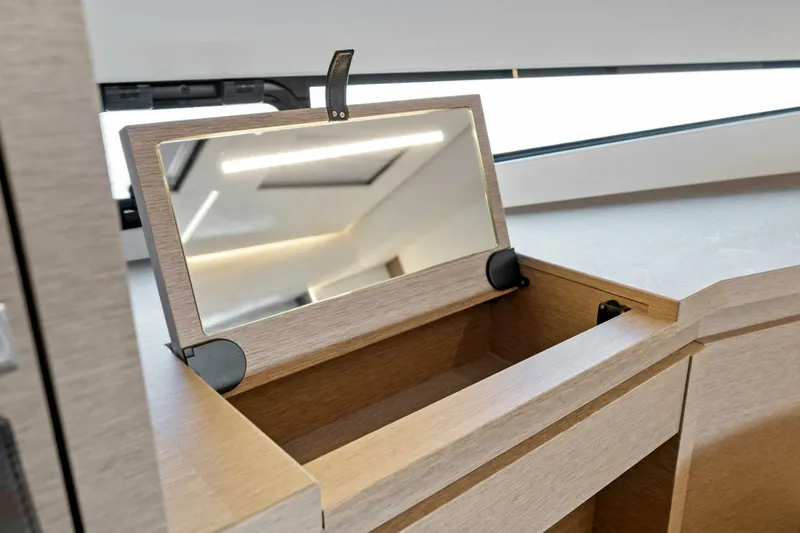 Slide: The Image of Prestige 460 Flybridge 2023 interior with open vanity mirror and storage compartment. - 37