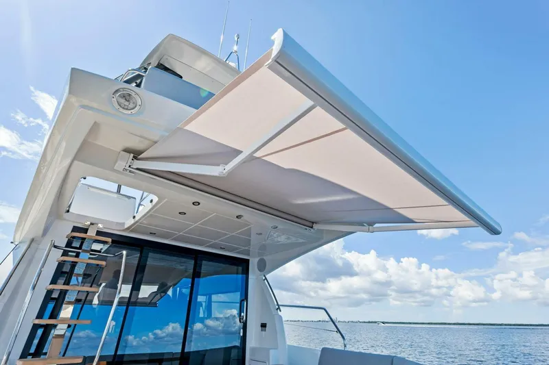Slide: The Image of Prestige 460 Flybridge 2023 yacht with extended sunshade on a sunny day. - 43