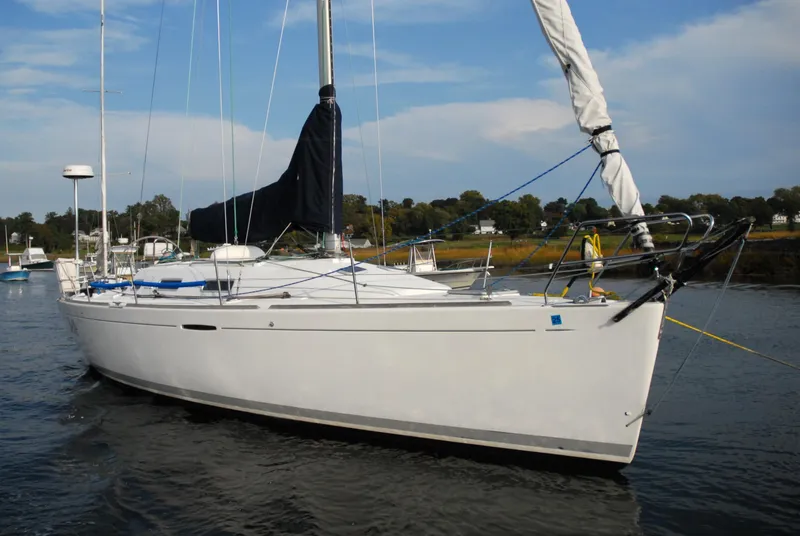 Slide: The Image of 2003 Beneteau 36.7 sailboat on calm water, clear sky background. - 1