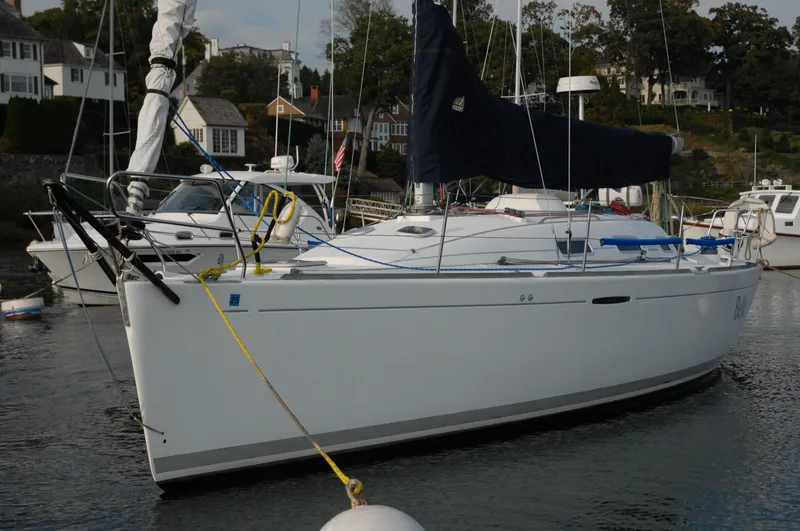 Slide: The Image of 2003 Beneteau 36.7 sailboat docked in a marina, surrounded by other boats. - 2