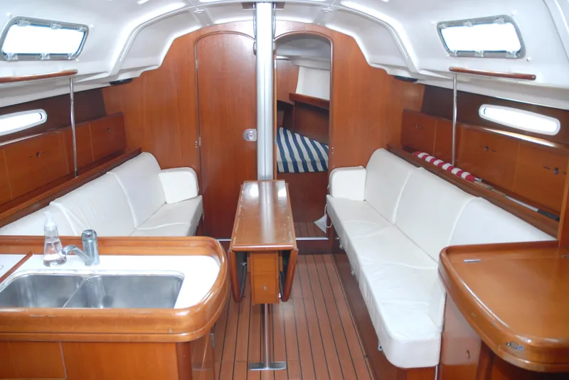 Slide: The Image of Interior of 2003 Beneteau 36.7 sailboat with wood finish and white seating. - 20