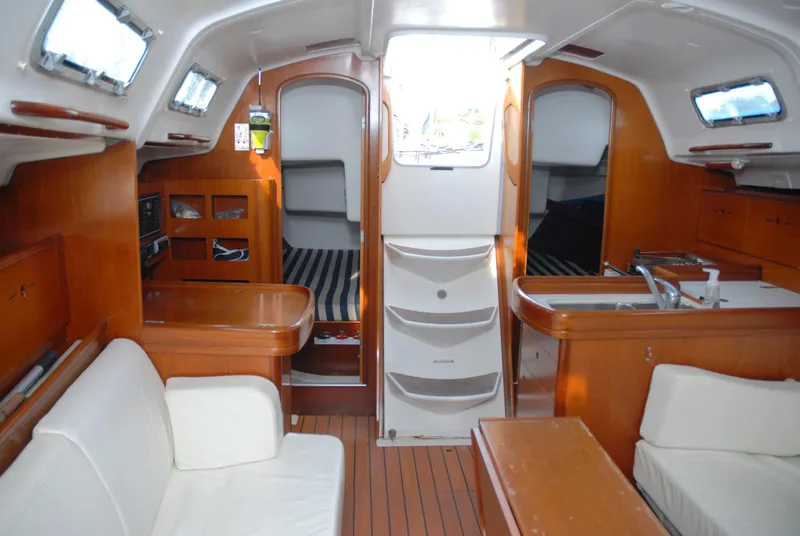 Slide: The Image of Interior of 2003 Beneteau 36.7 sailboat with wood finish and white seating. - 24