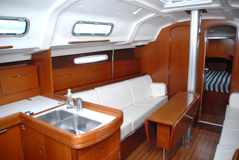 Slide: The Image of Interior of 2003 Beneteau 36.7 yacht with wood finish and white seating. - 26
