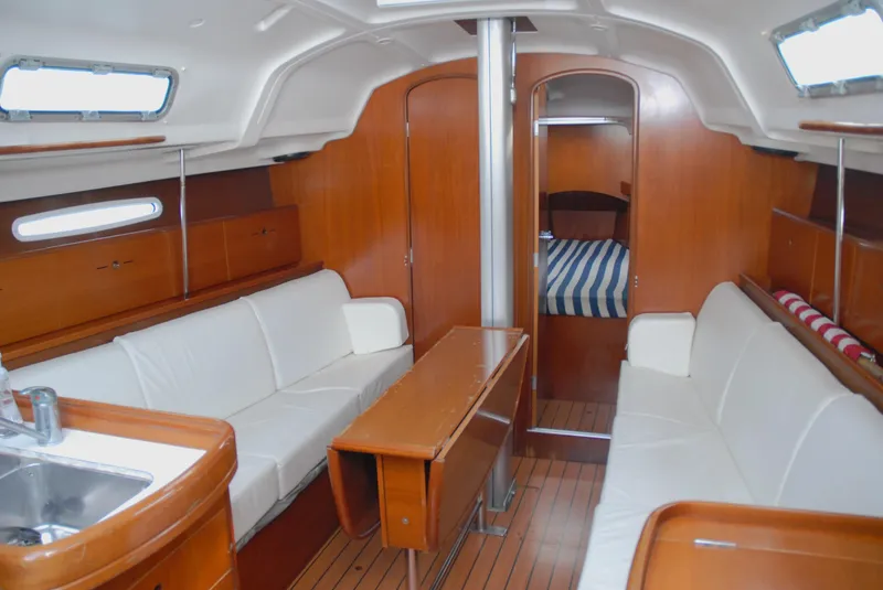 Slide: The Image of Interior of 2003 Beneteau 36.7 sailboat with wood finish and white seating. - 27