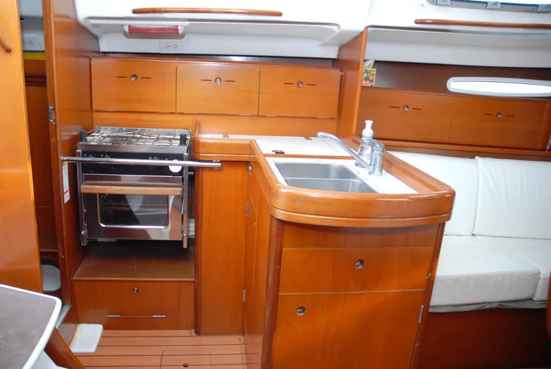 Slide: The Image of Interior of 2003 Beneteau 36.7 yacht with wooden cabinetry and kitchen amenities. - 28