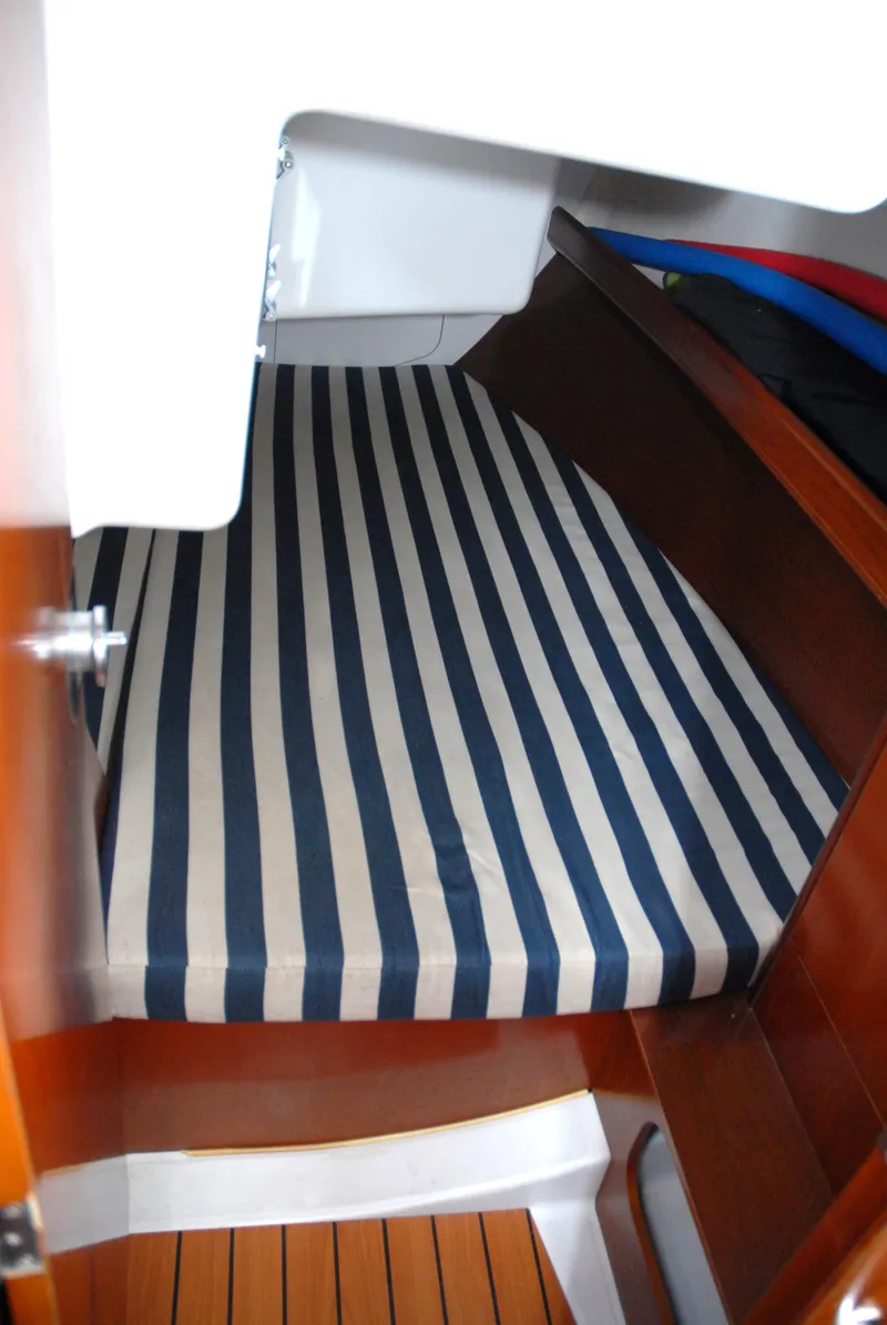 Slide: The Image of Beneteau 36.7 2003 cabin interior with striped mattress and wooden accents. - 30