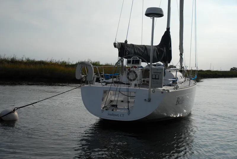 Slide: The Image of 2003 Beneteau 36.7 sailboat anchored in calm water, rear view. - 5