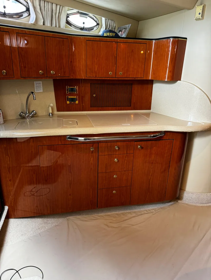Slide: The Image of Luxurious 2001 Sea Ray 410 Sundancer yacht interior with elegant wood cabinetry and sleek countertops. - 14