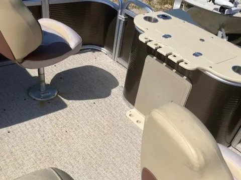 Slide: The Image of 2019 Tahoe Pontoon GT 2385 interior with beige seating and table. - 8