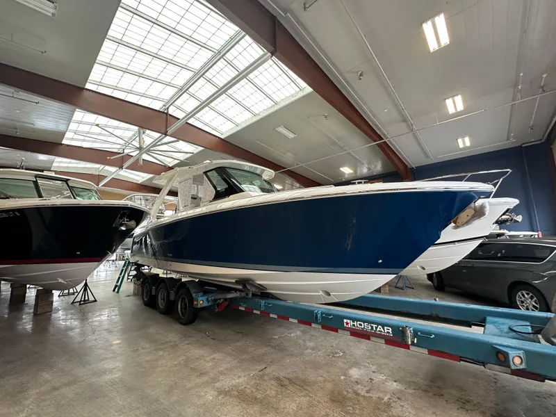 The Image of 2025 Tiara Yachts 34 LS in showroom, blue hull, on trailer. - 0