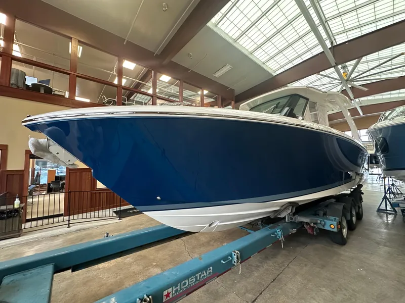 Slide: The Image of 2025 Tiara Yachts 34 LS in showroom, sleek blue hull on trailer. - 1