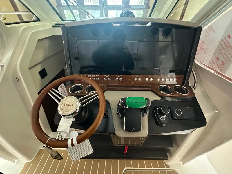 Slide: The Image of 2025 Tiara Yachts 34 LS helm with modern controls and wooden steering wheel. - 11