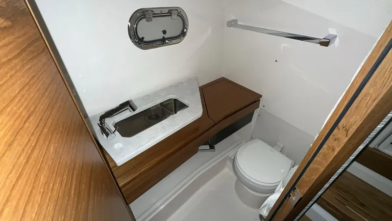 Slide: The Image of 2025 Tiara Yachts 34 LS bathroom with modern fixtures and wooden accents. - 14