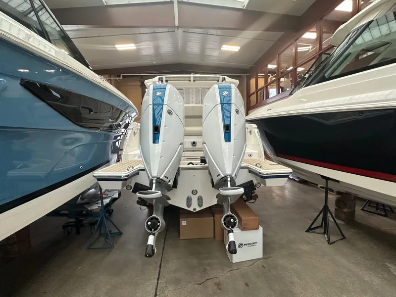 Slide: The Image of 2025 Tiara Yachts 34 LS with dual outboard engines in a showroom. - 2