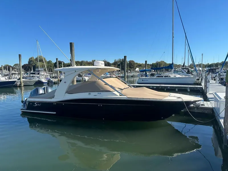 Slide: The Image of 2015 Scout 275 Dorado boat docked in marina under clear blue sky. - 0