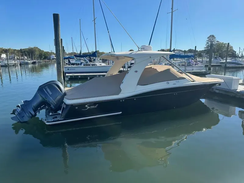 Slide: The Image of 2015 Scout 275 Dorado boat docked in a marina with clear blue skies. - 1