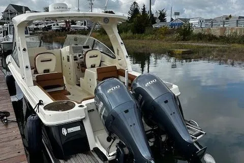 Slide: The Image of 2015 Scout 275 Dorado boat with twin engines docked by a calm waterway. - 11