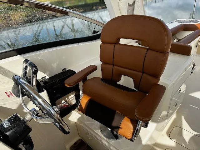 Slide: The Image of 2015 Scout 275 Dorado helm with brown captain's chair and steering wheel. - 6
