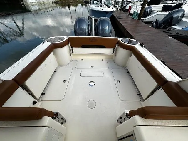 Slide: The Image of 2015 Scout 275 Dorado boat interior with brown seating, docked by the water. - 9