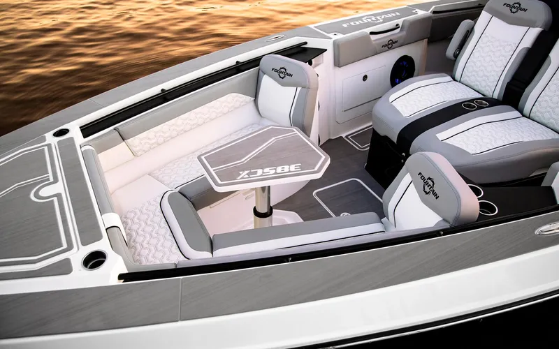 Slide: The Image of 2025 Fountain 38 SCX boat interior with luxurious seating and table on calm water. - 10