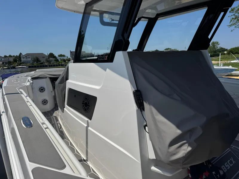 Slide: The Image of 2025 Fountain 38 SCX boat, sleek design, docked with covered seating area. - 29
