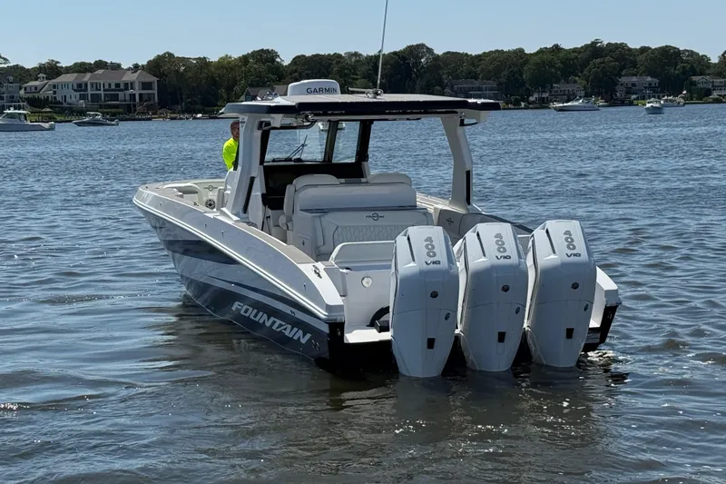 Slide: The Image of 2025 Fountain 38 SCX boat with triple outboard engines on a calm lake. - 34