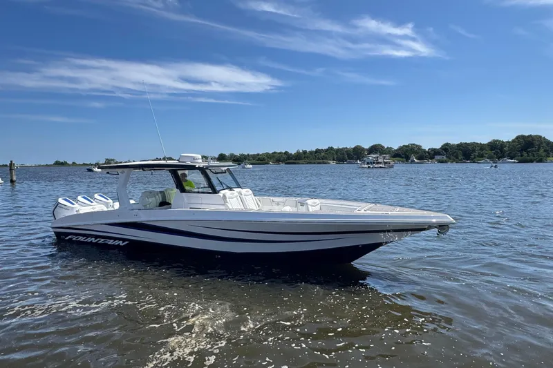 Slide: The Image of 2025 Fountain 38 SCX boat on a sunny lake, showcasing sleek design and powerful engines. - 38