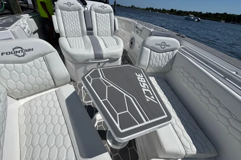 Slide: The Image of Luxurious 2025 Fountain 38 SCX boat interior with stylish seating and table on a sunny day. - 39
