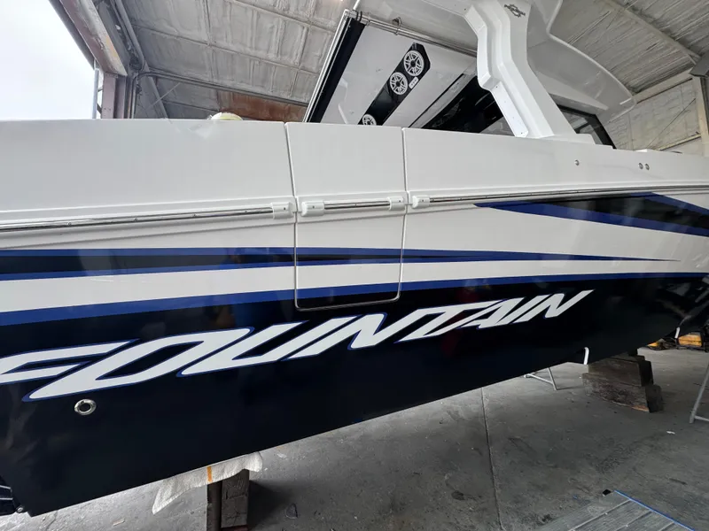Slide: The Image of 2025 Fountain 38 SCX boat in a garage, showcasing sleek design and branding. - 5