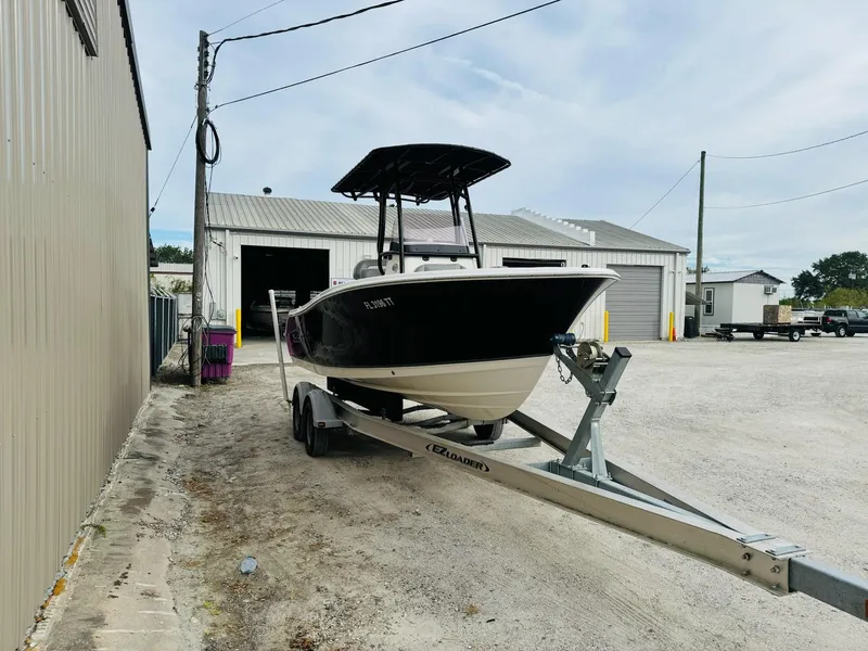 Slide: The Image of 2022 NauticStar 2102 Legacy boat on trailer outside a warehouse. - 12