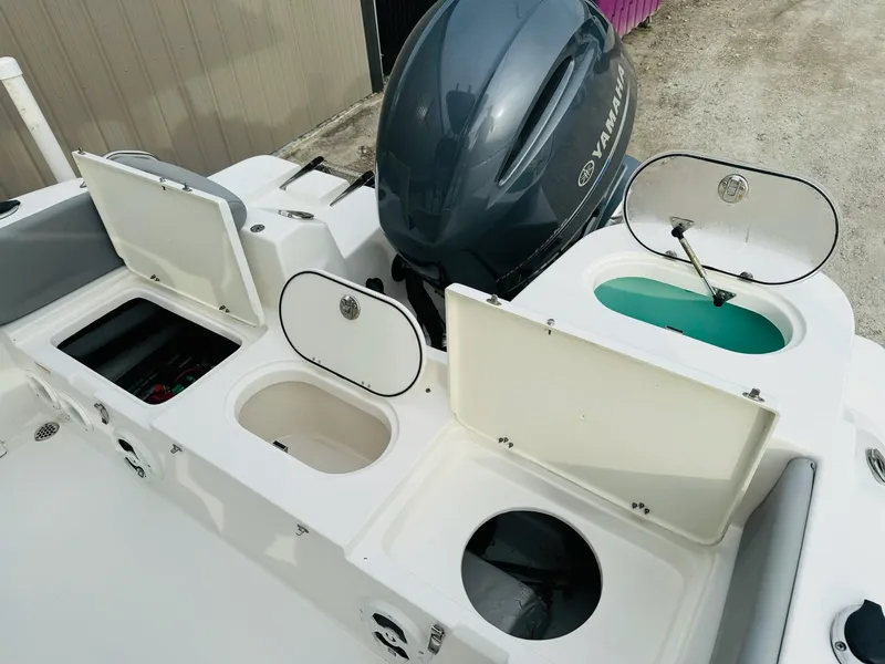 Slide: The Image of NauticStar 2102 Legacy 2022 boat with open storage compartments and Yamaha engine. - 25