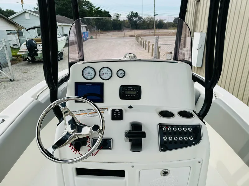 Slide: The Image of 2022 NauticStar 2102 Legacy boat dashboard with steering wheel and control panel. - 27