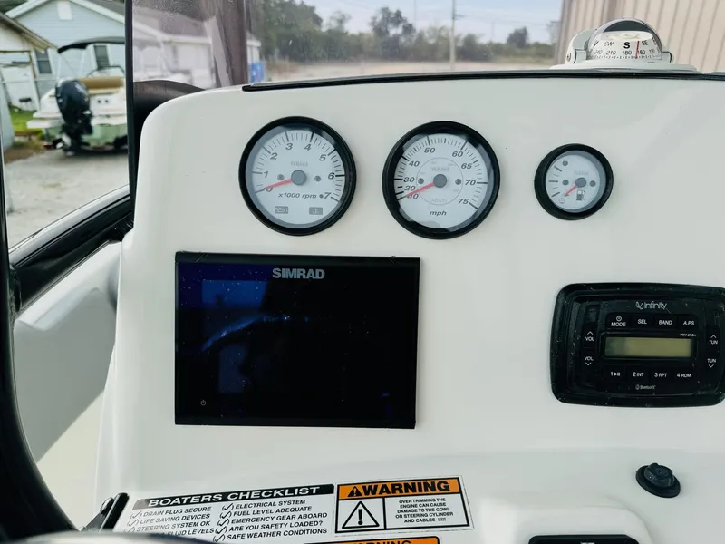 Slide: The Image of Dashboard of 2022 NauticStar 2102 Legacy boat with gauges and Simrad display. - 28