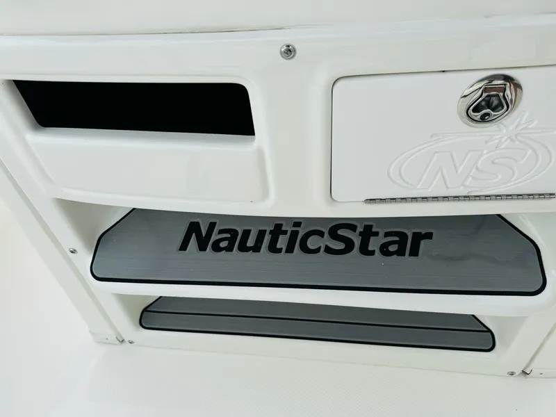 Slide: The Image of NauticStar 2102 Legacy 2022 boat interior detail with logo and storage compartment. - 43